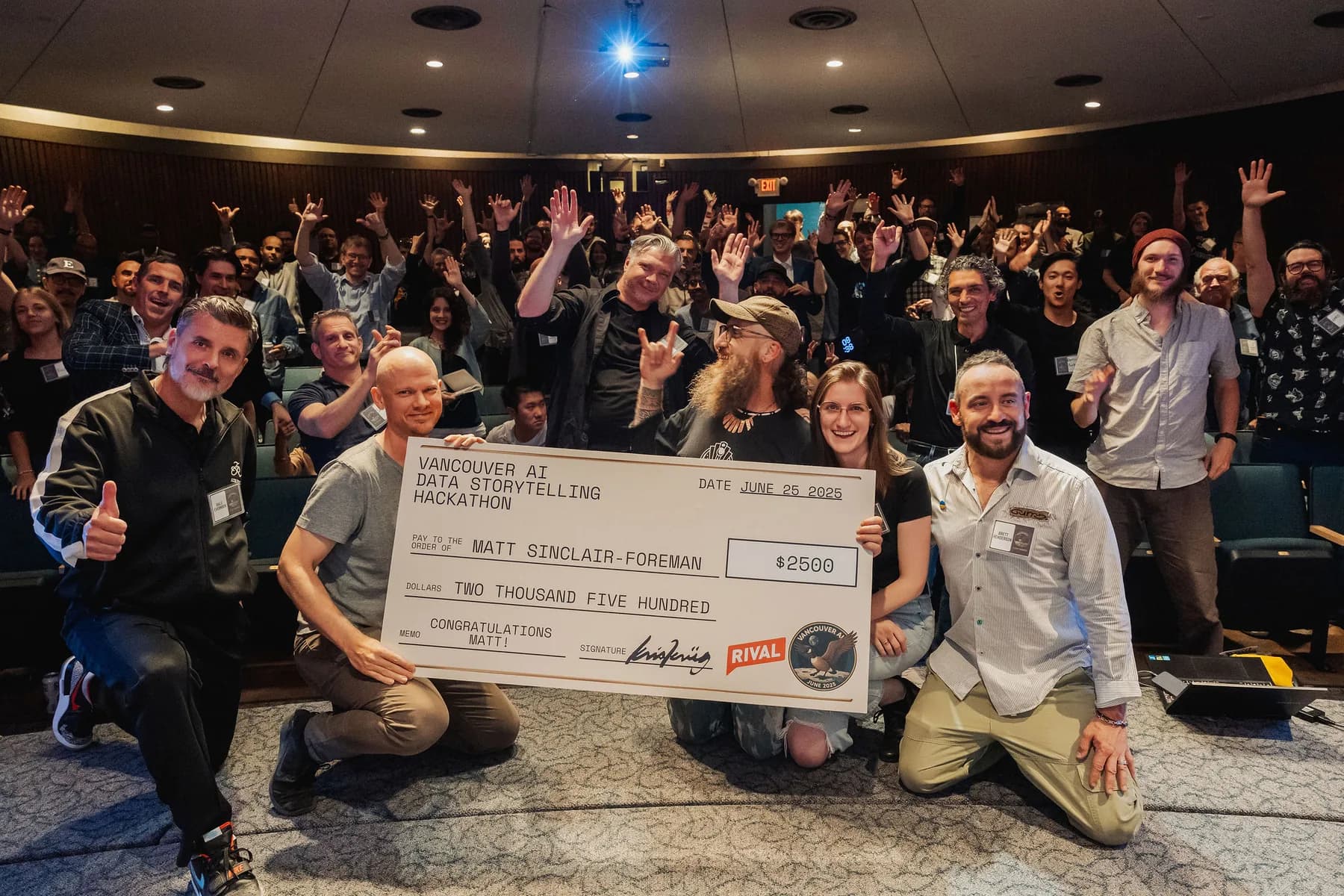 Prize moment with an audience behind it at a Vancouver AI gathering