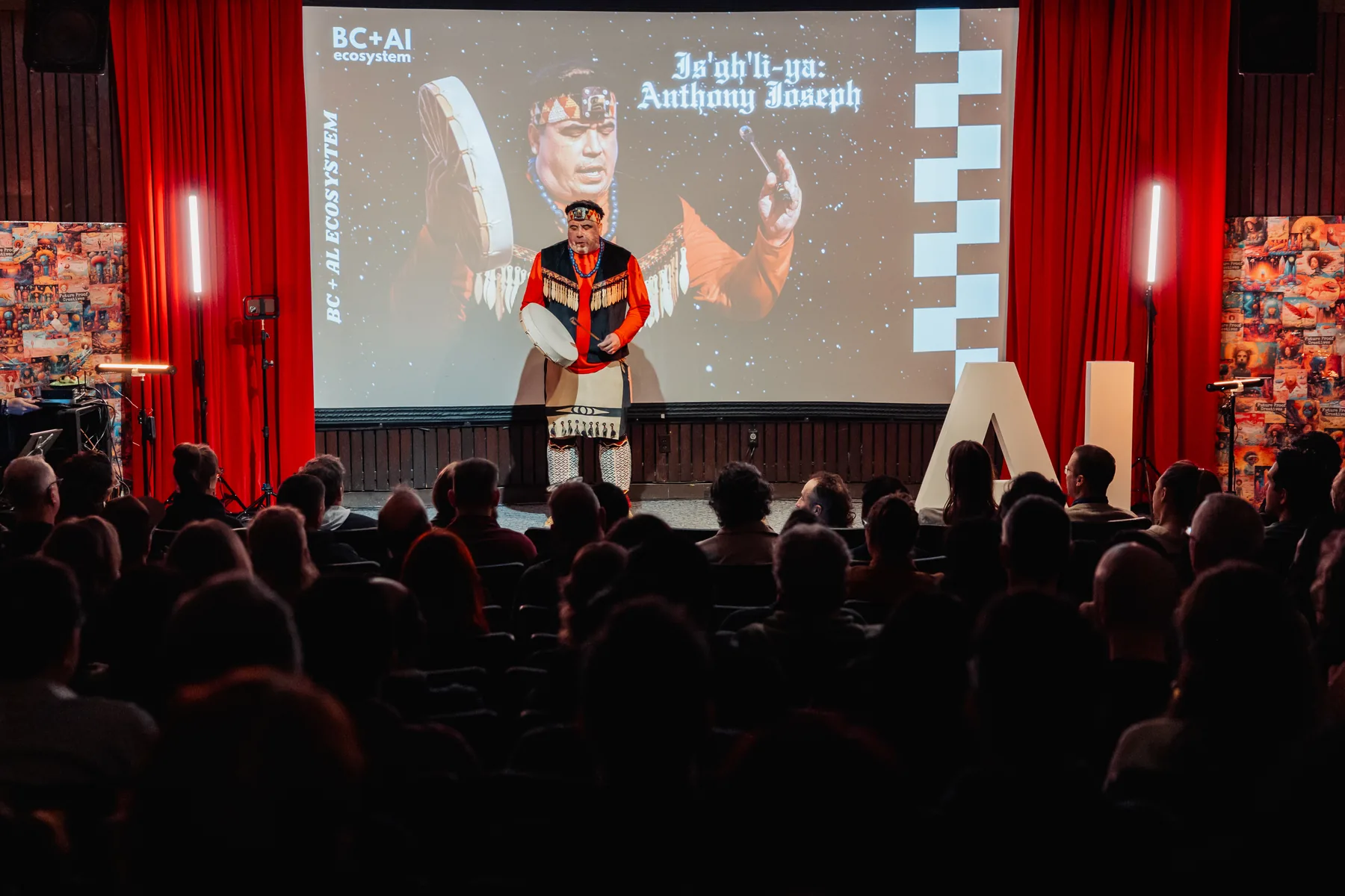 A performer holding the stage with a microphone while the audience watches in silhouette