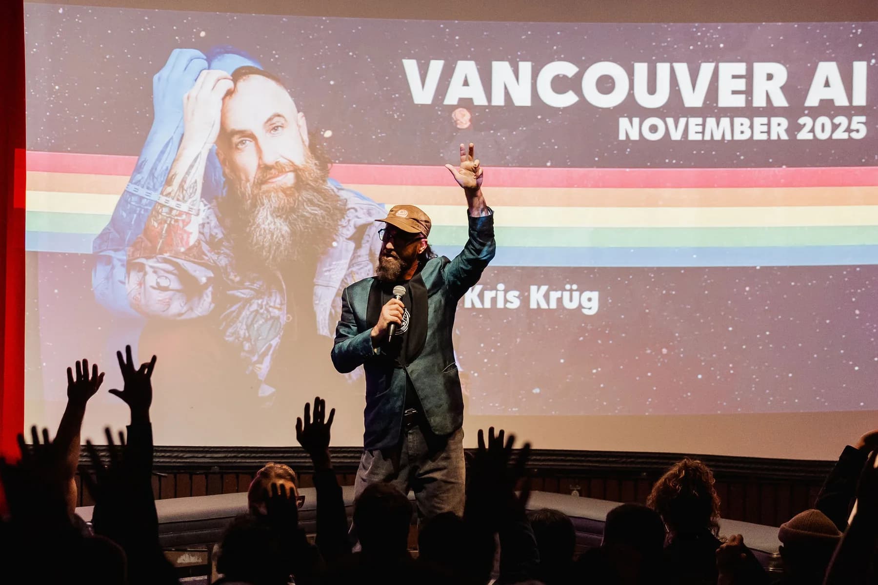 Kris on stage with raised hands in front of a Vancouver AI audience