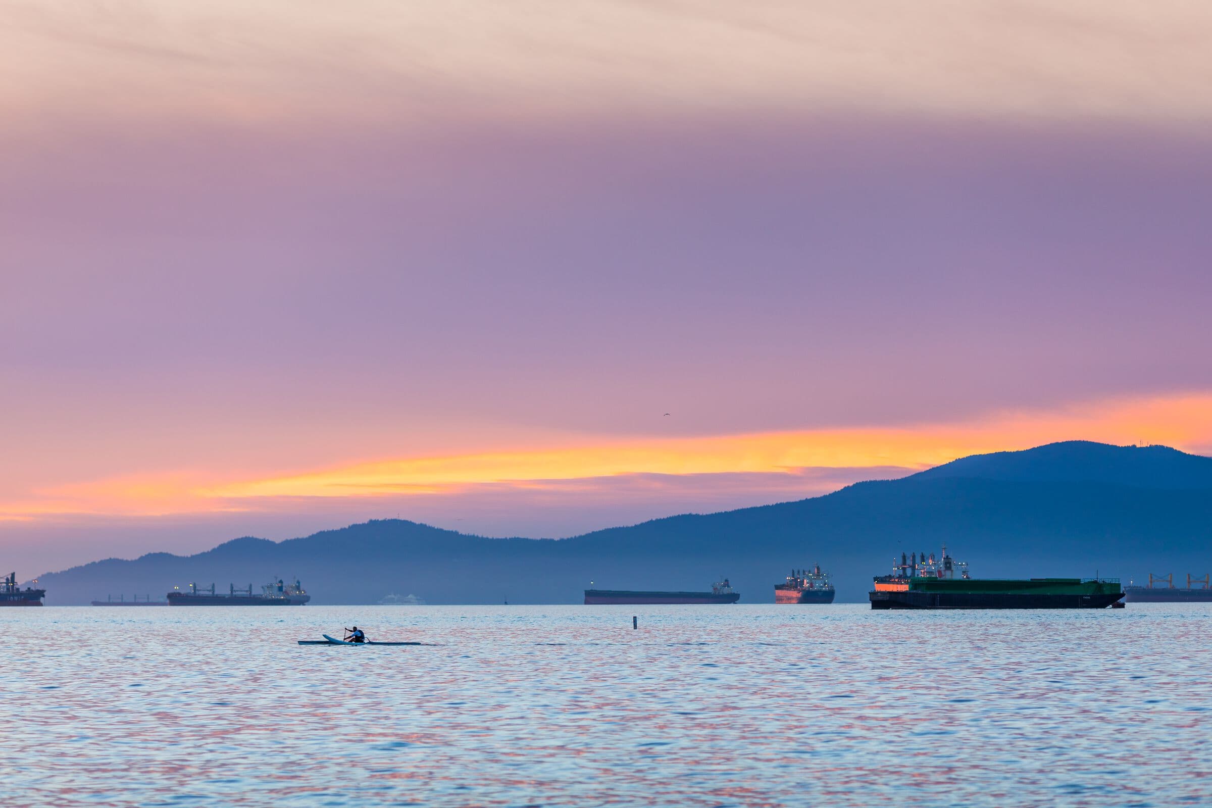 A rower crossing English Bay at sunset