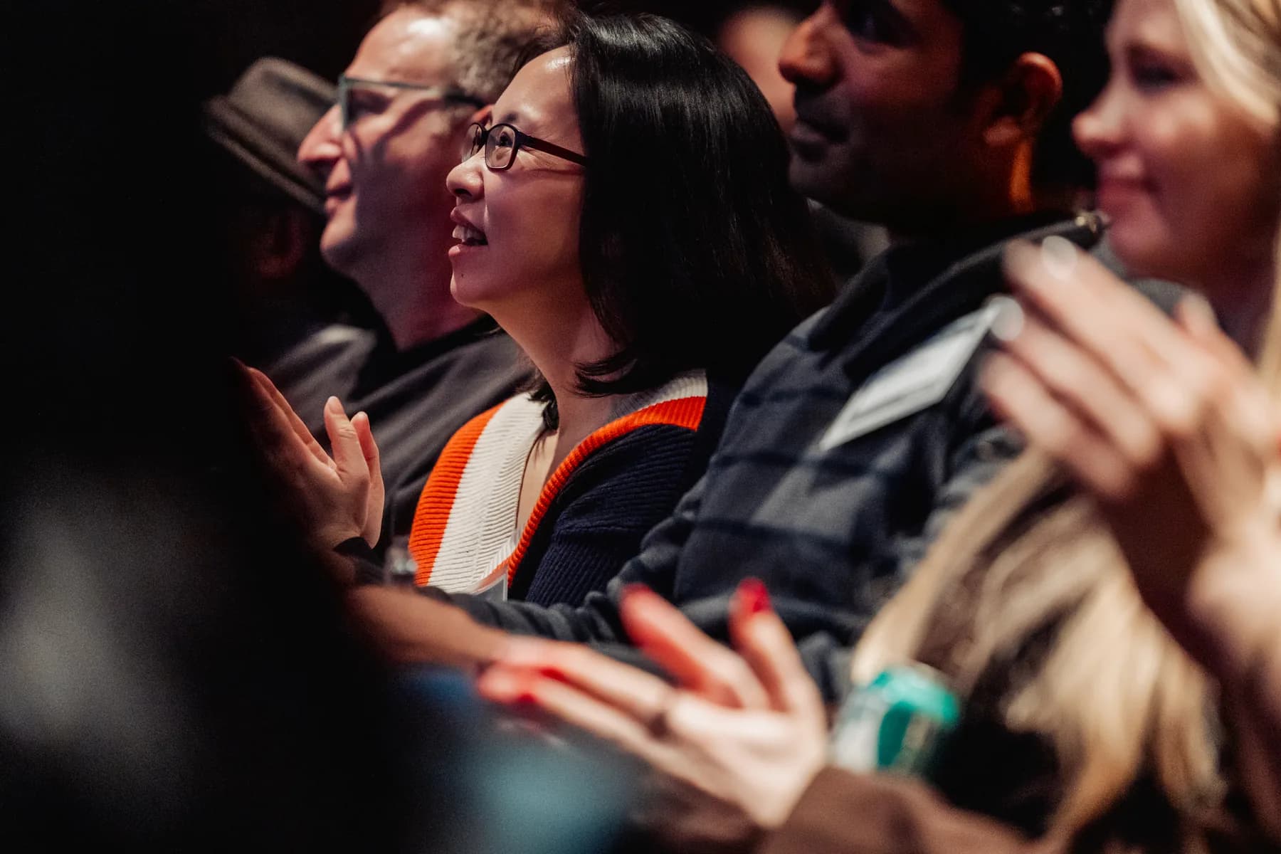 A close-up of an audience member mid-applause, caught paying close attention
