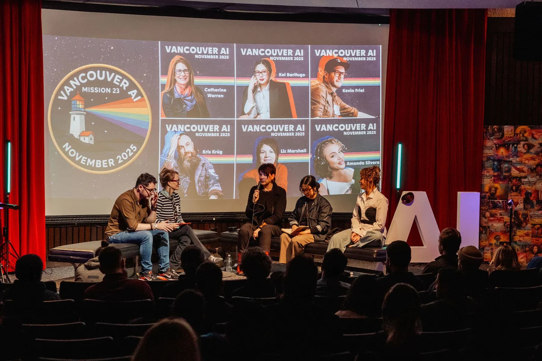 A wide shot of a Vancouver AI panel discussion with audience silhouettes in the foreground