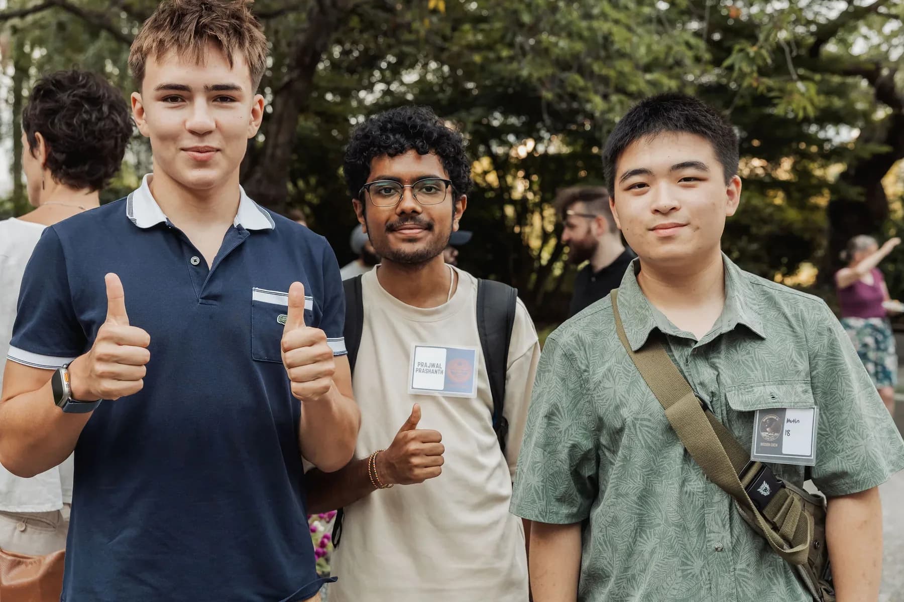 Three young AI builders pose together outdoors at the Vancouver AI gathering.