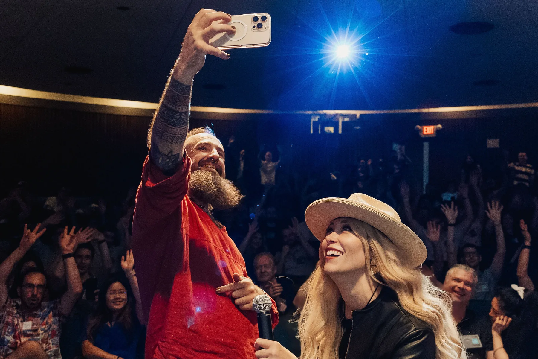 Selfie-style Vancouver AI community moment with the audience cheering behind the hosts